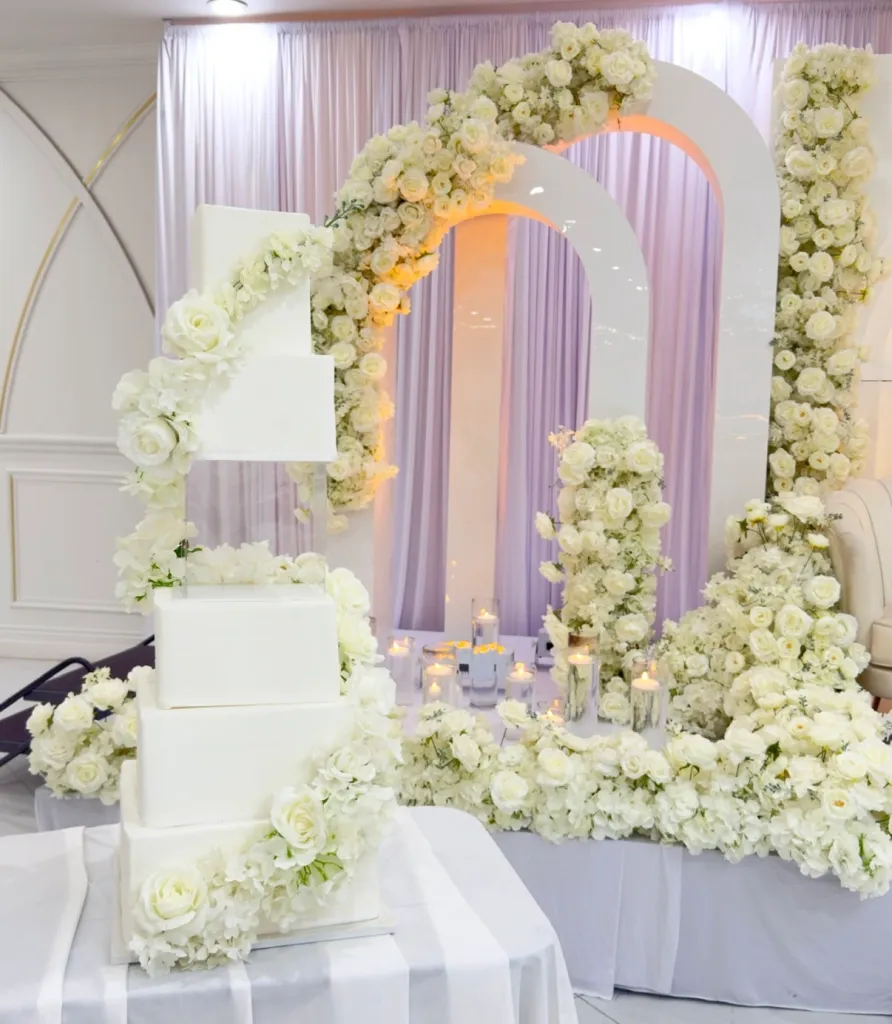 Tiered faux wedding cake with cascading floral detail by Aya's Sweets